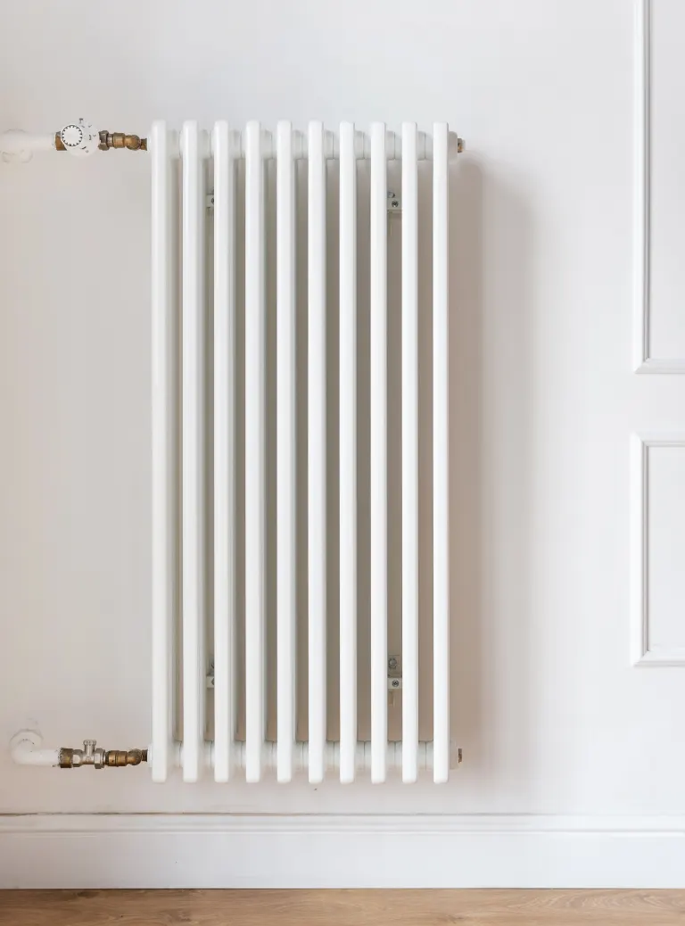 Biały kaloryfer zawieszony na ścianie